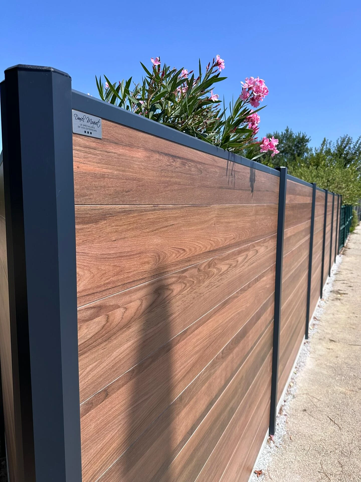 Clôture DoMaStyl' plein Effet bois Teck et poteaux gris 7016 avec plaques de soubassement béton