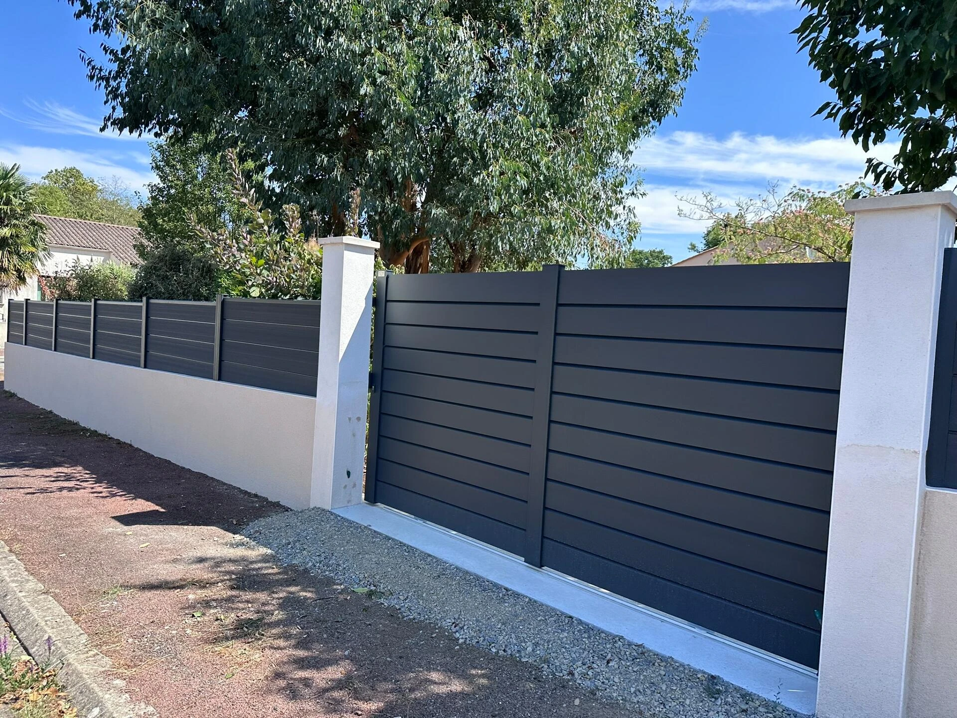 Clôture DoMaStyl' plein graphite poteaux gris 7016 sur muret et portail coulissant Classic Strong
