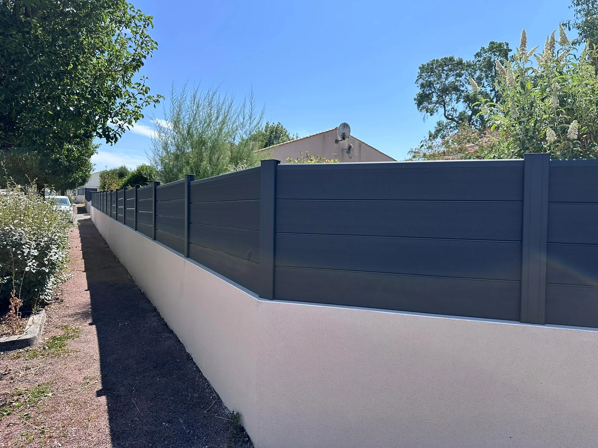 Clôture DoMaStyl' plein graphite poteaux gris 7016 sur muret et portail coulissant Classic Strong