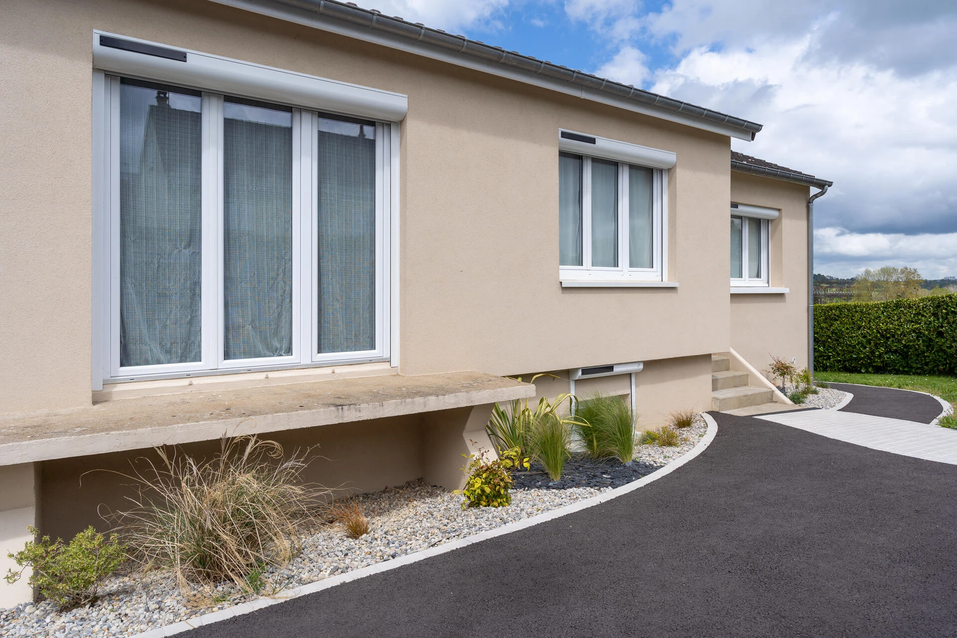 Création paysagère avec galets, ardoises et végétaux + entrée de maison en enrobé à chaud et pavage