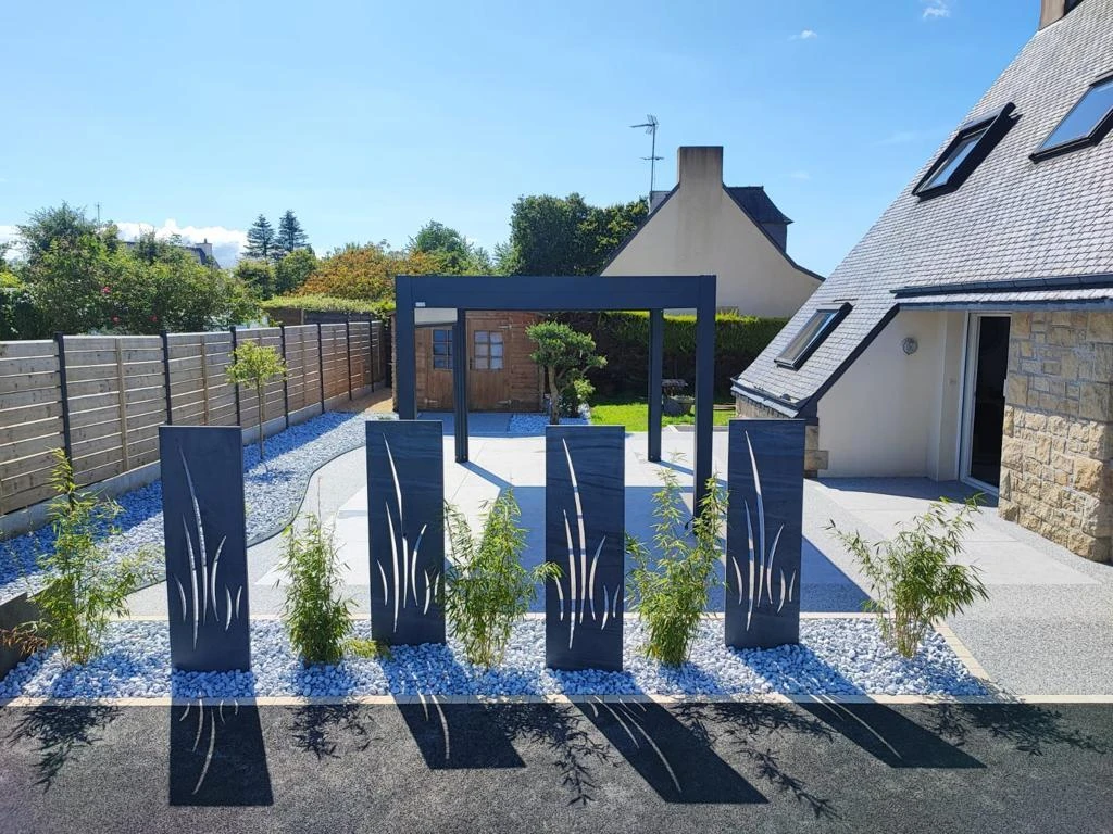 Création paysagère avec galets et végétations terrasse en Hydrostar, dallage et pergola