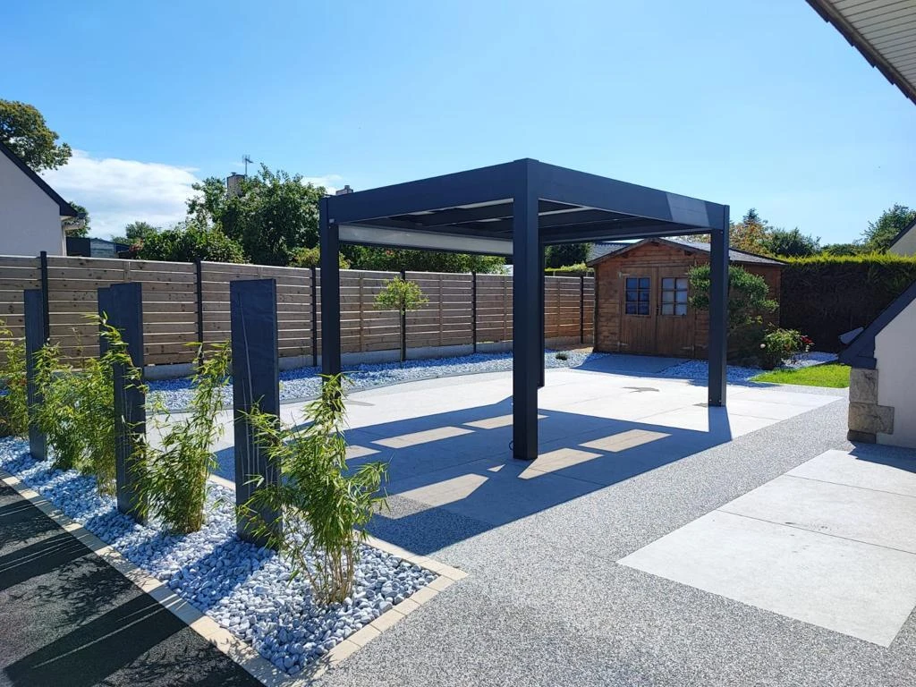 Création paysagère avec galets et végétations terrasse en Hydrostar, dallage et pergola