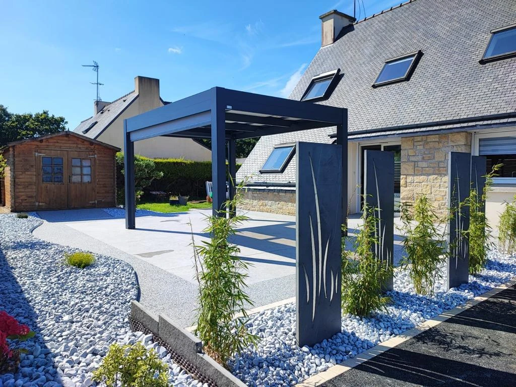 Création paysagère avec galets et végétations terrasse en Hydrostar, dallage et pergola