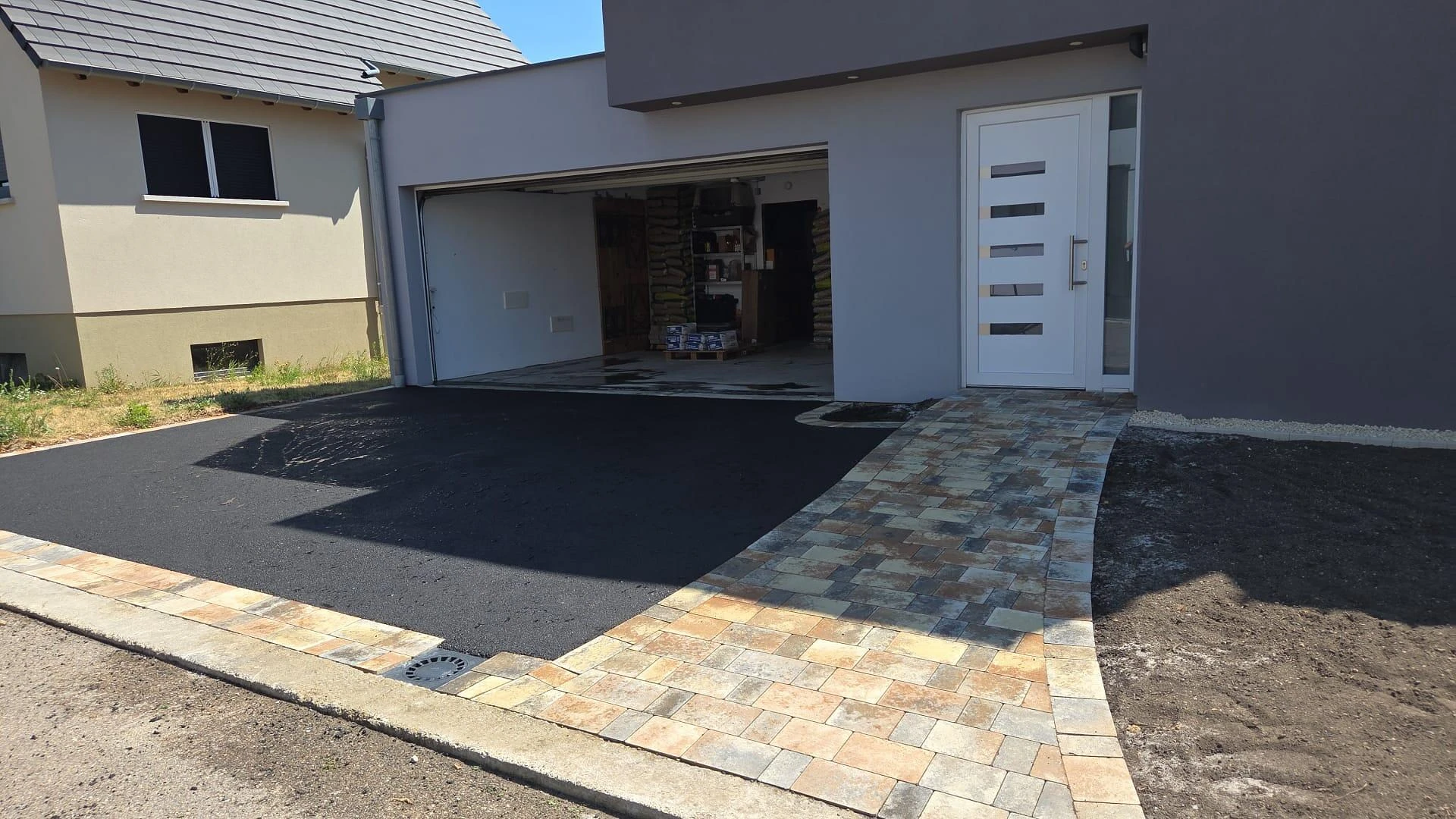 Entrée de maison en pavage Antiquita dune700  et enrobe noir a chaud