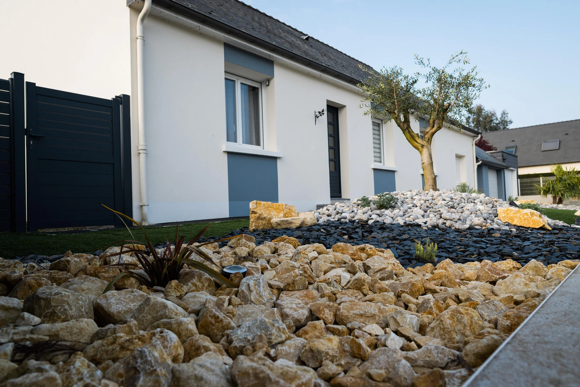 Massif paysager avec paillage minéral pour entrée de maison