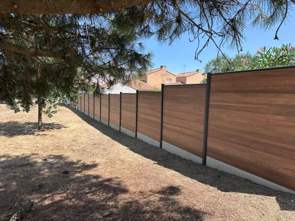 Clôture DoMaStyl' plein Effet bois Teck et poteaux gris 7016 avec plaques de soubassement béton