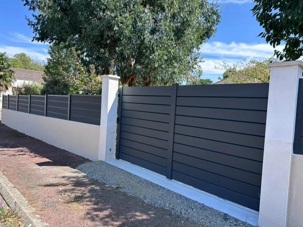Clôture DoMaStyl' plein graphite poteaux gris 7016 sur muret et portail coulissant Classic Strong