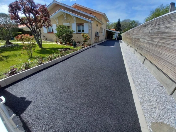 Cour en enrobé noir à chaud et bande drainante en graviers gris perle