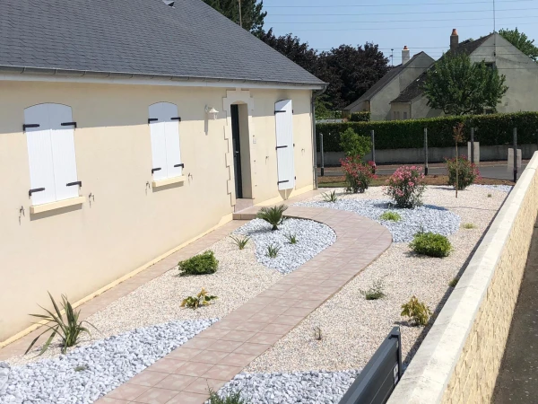Création de massifs paysagers avec galets et plantation d'un arbre et d'arbustes