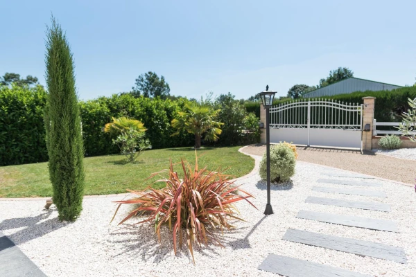 Entrée de maison en Gravistar® et massif paysager