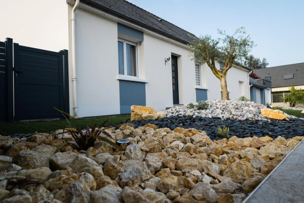 Massif paysager avec paillage minéral pour entrée de maison