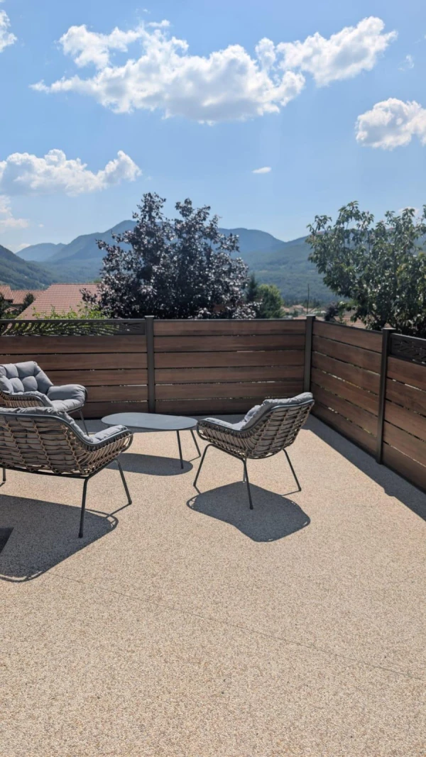 Terrasse en béton désactivé et clôture DoMaStyl' persienne effet bois avec décors